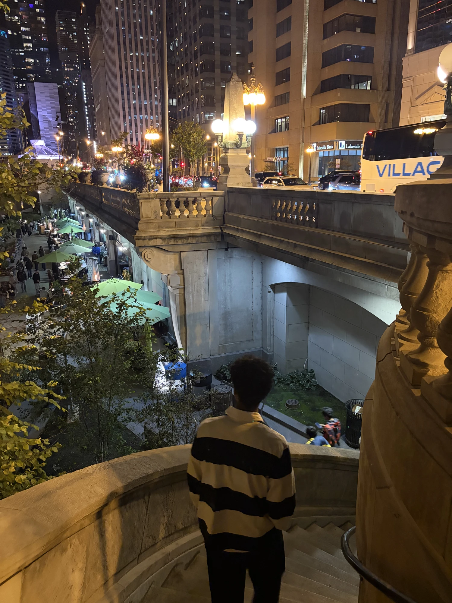 Dev looking out over a riverwalk at night